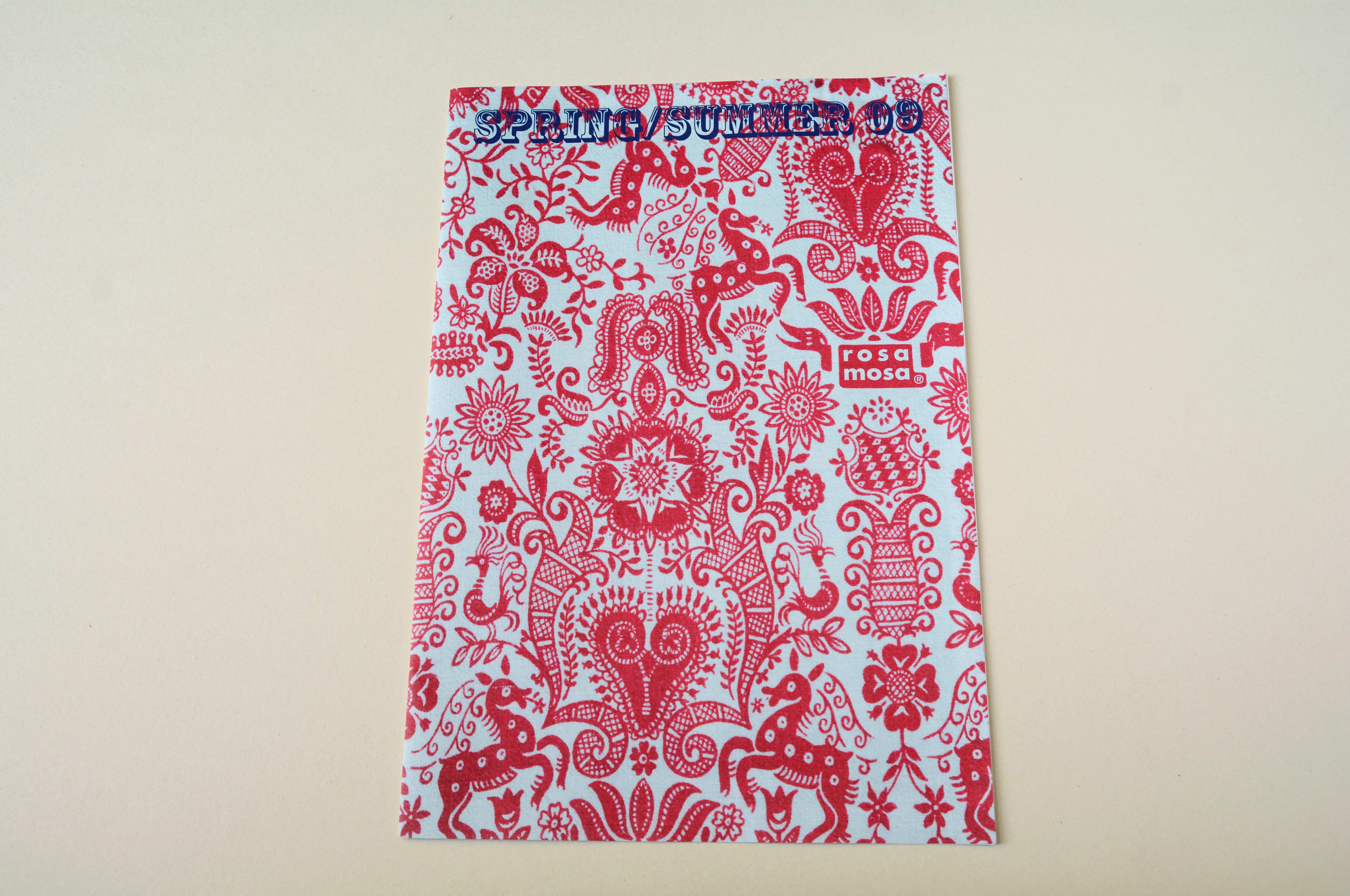 Cover catalogue. Figurative pattern in red with incorporated logo. Blue title font overlayed.