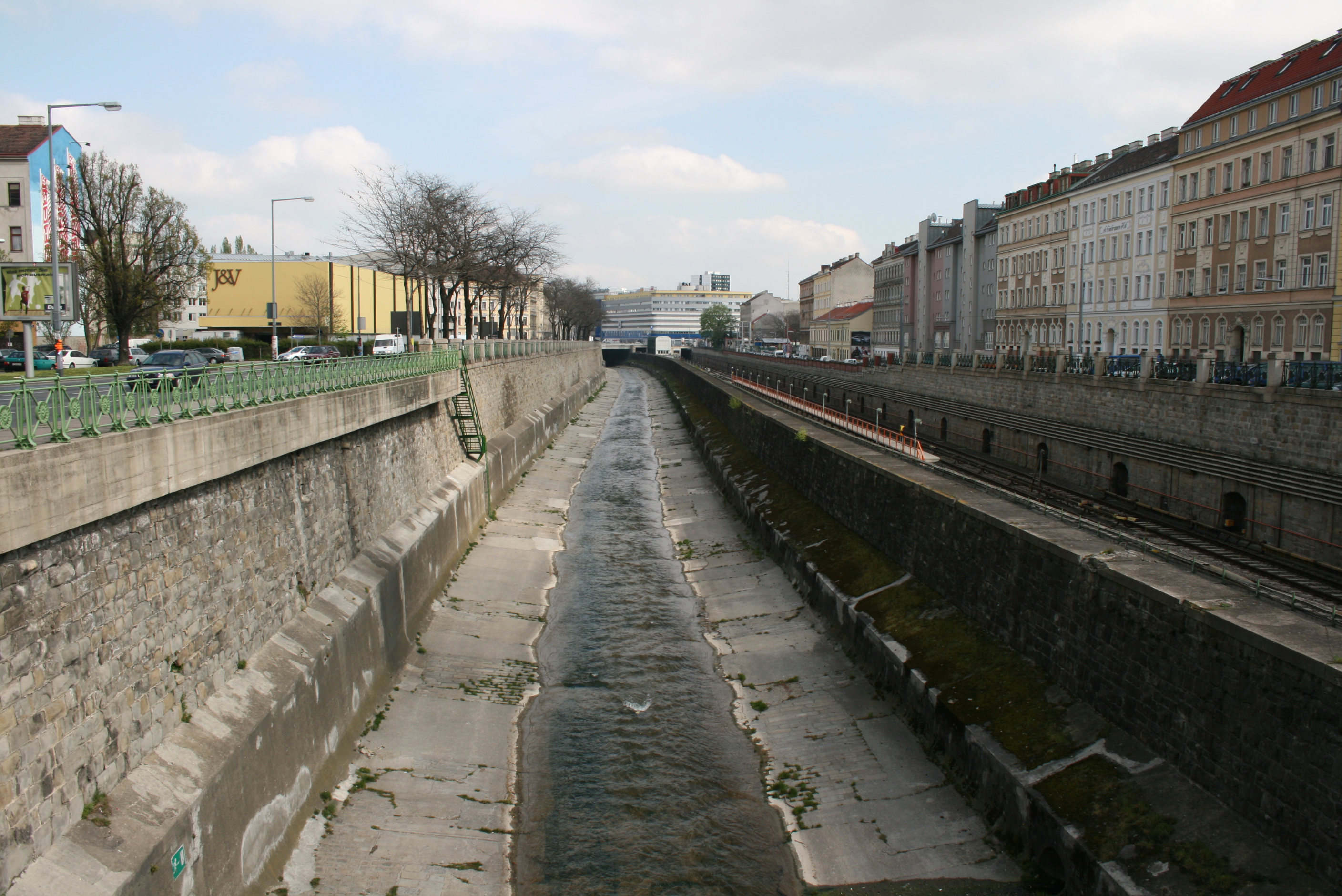River runs in an artifical canal. Streets on both sides.