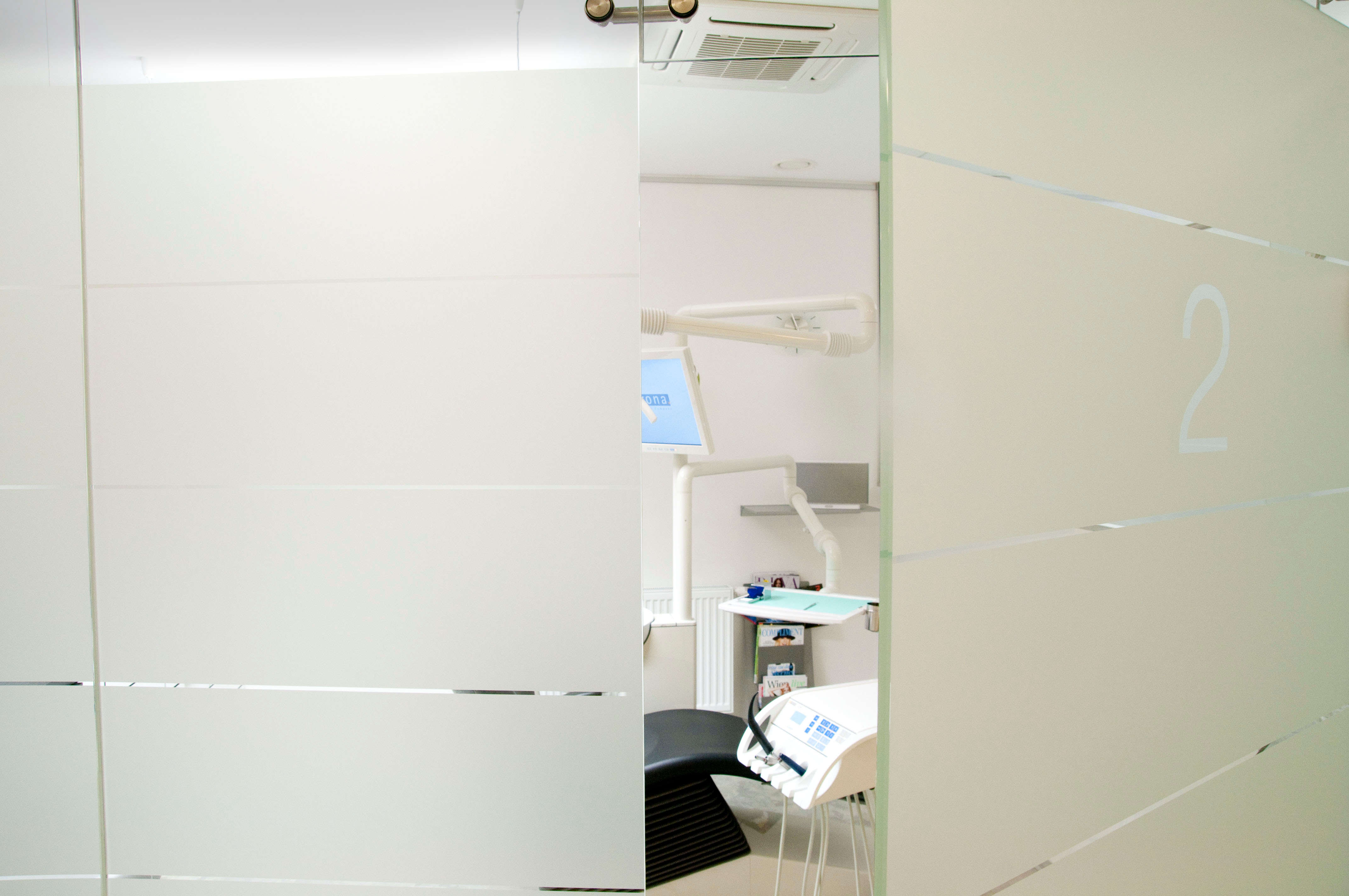 Inside dentist's practice. Looking trough half opened door of treatment room.
