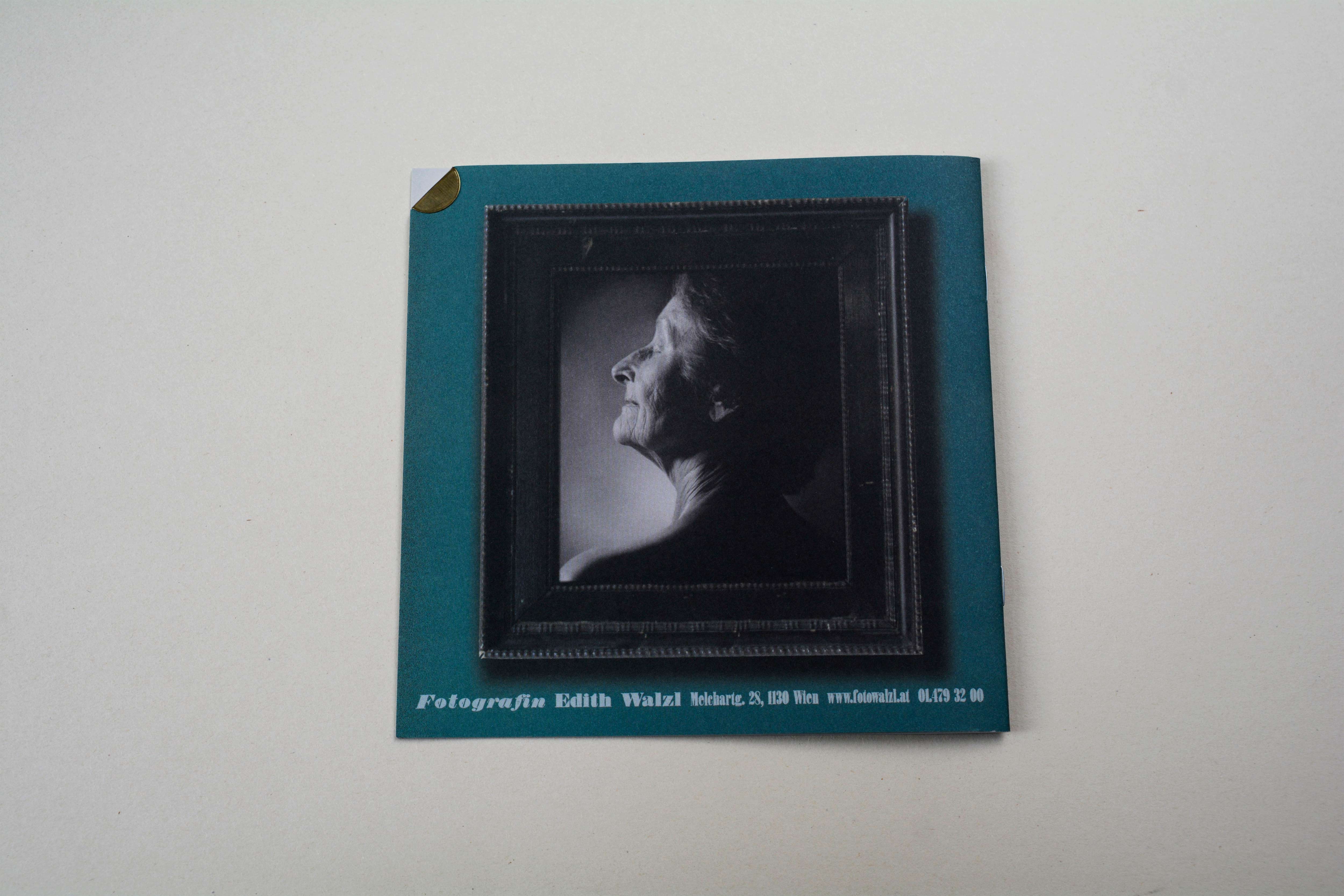 Back brochure. Massive wooden frame with b/w portrait over whole area.
