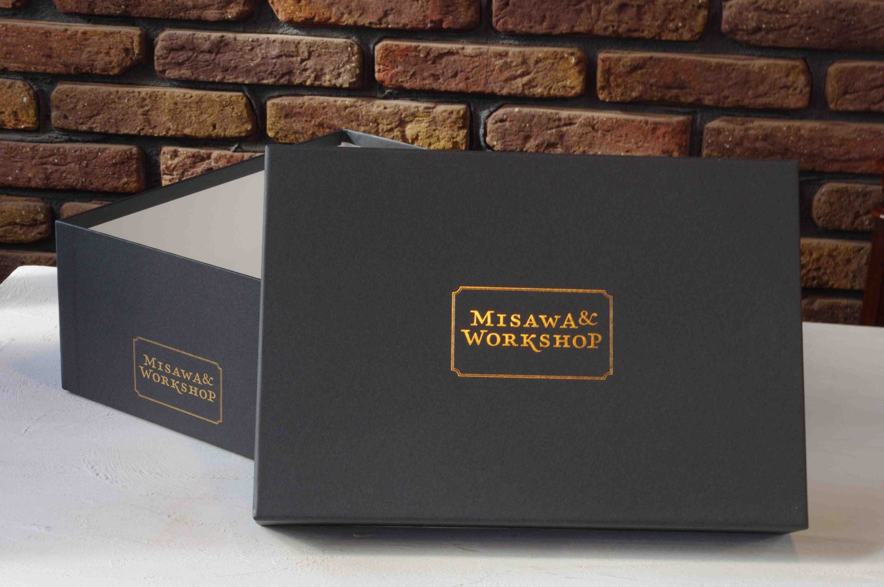 Black shoe box. Logo printed in gold at side and on lid.