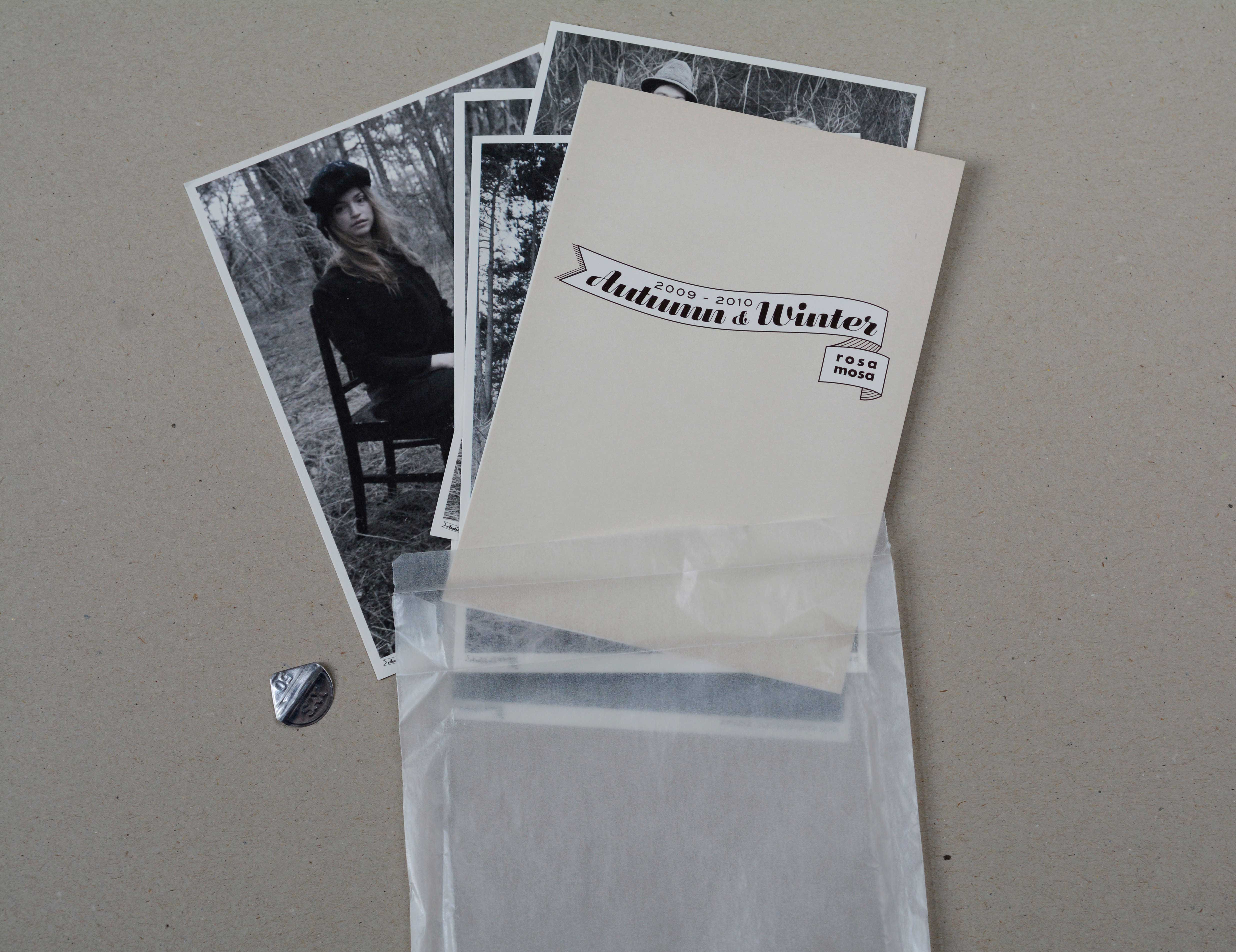 Set of postcards pulled out of transparent paper bag. Top card shows graphical element with title.