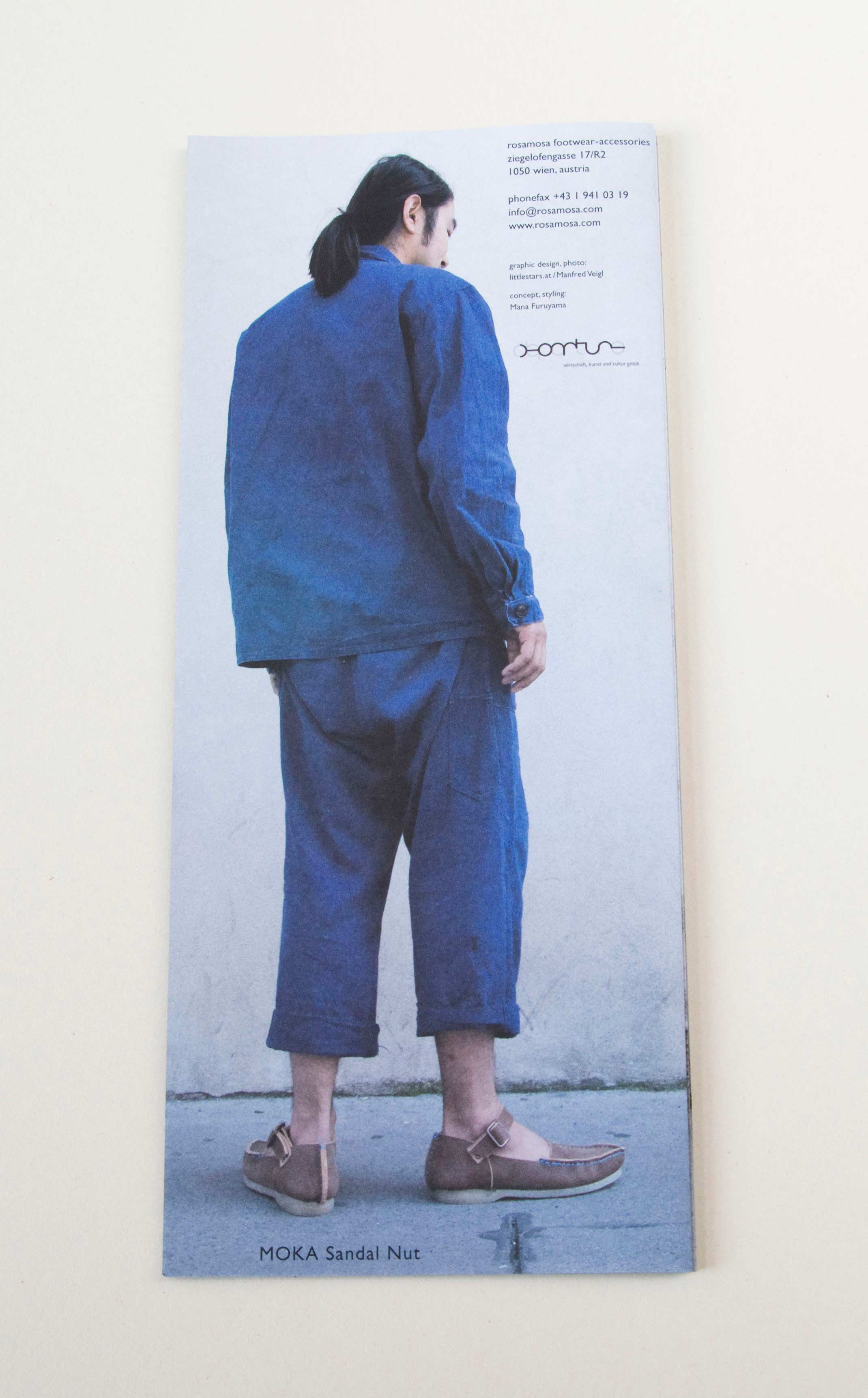 Back of zig-zag folded brochure. Full-page photo of man turned away standing on the street on front of white wall. Small blocks of text overlayed.