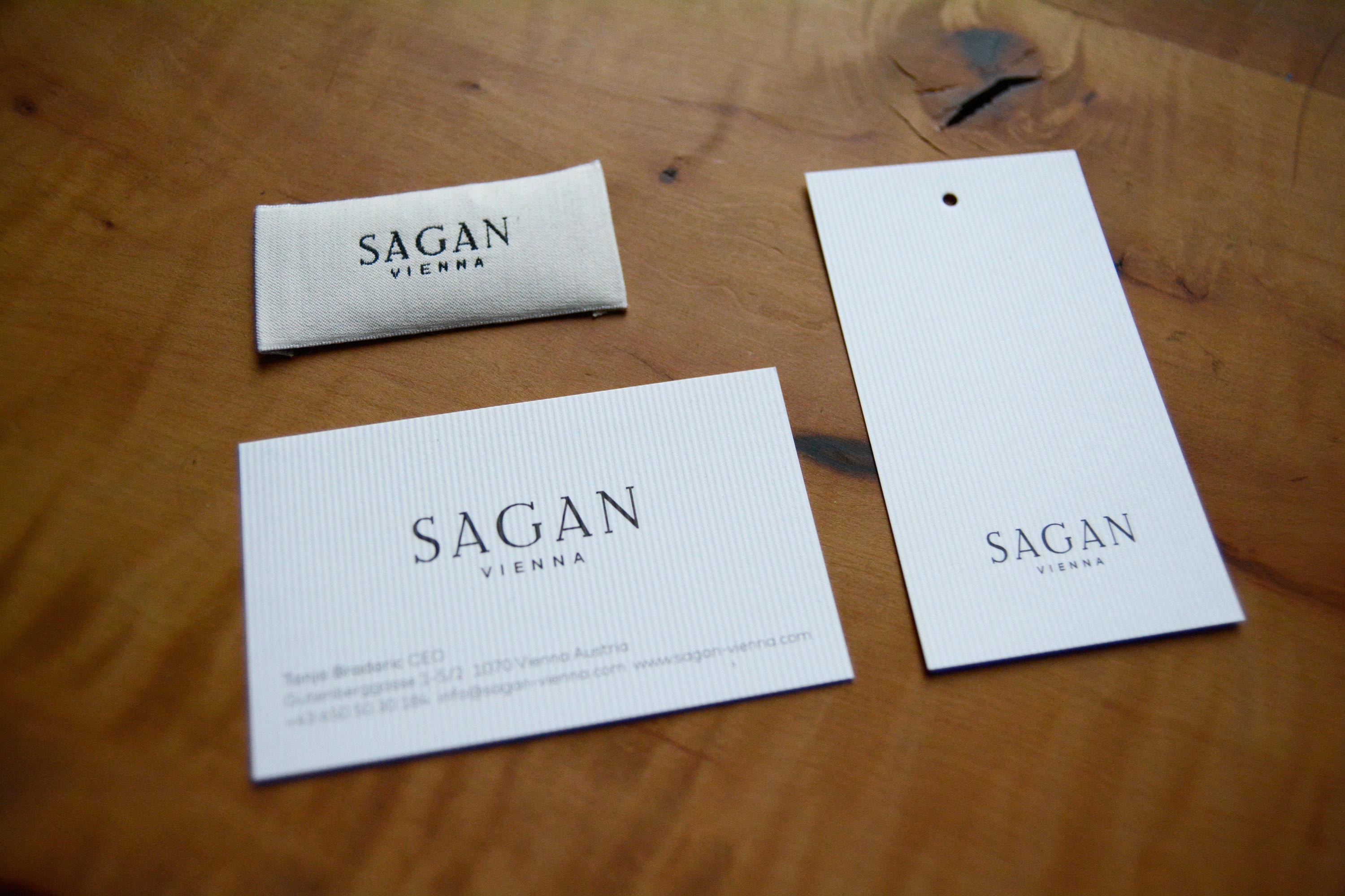 Small items lying on wooden table. Logo printed or stitched on each item.