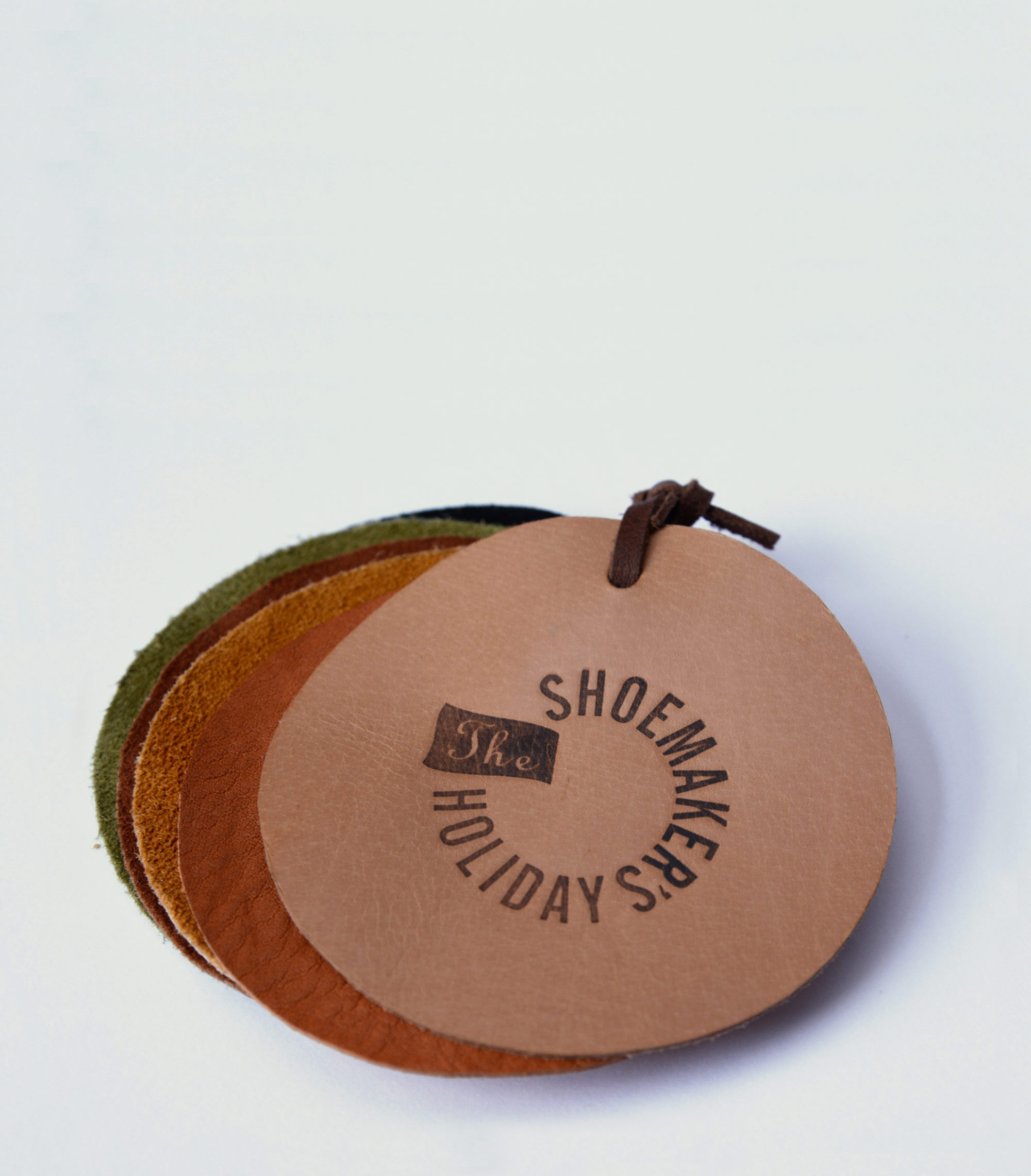 Bunch of coloured leather swatches. Top one punched with Logo.